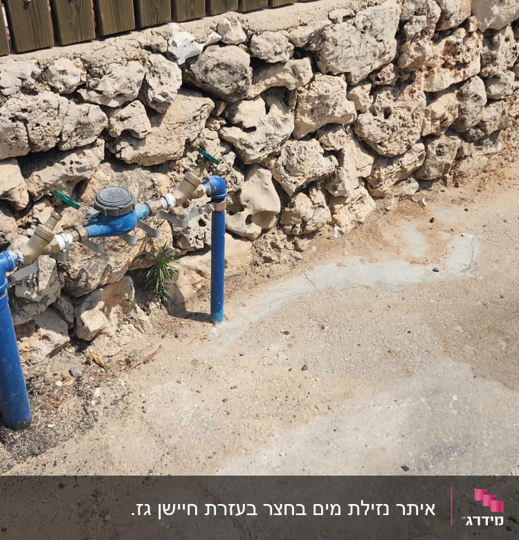 שני ברזים כחולים ליד קיר אבן